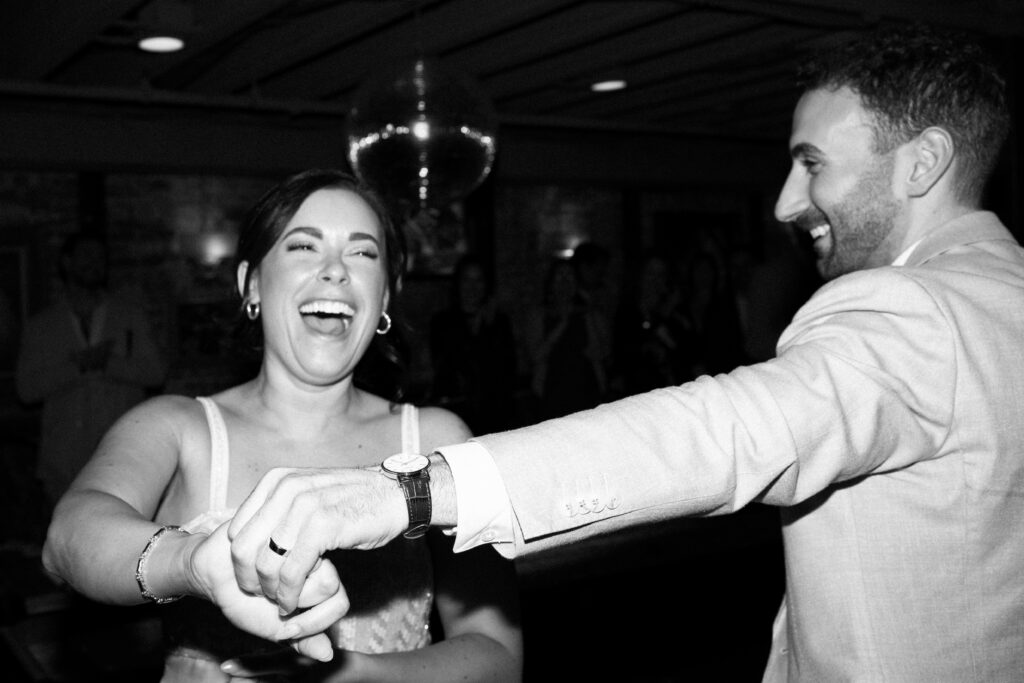 Sean and Giana laughing together while dancing during their Jersey City elopement celebration
