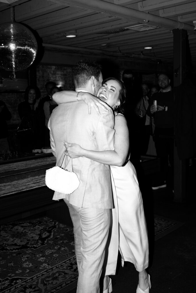 Giana hugging Sean tightly on the dance floor during their Jersey City elopement reception