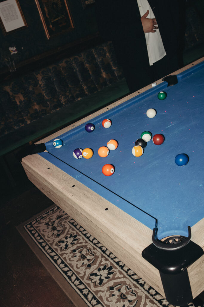 Blue pool table with scattered billiard balls inside the reception venue at Sean and Giana’s Jersey City elopement