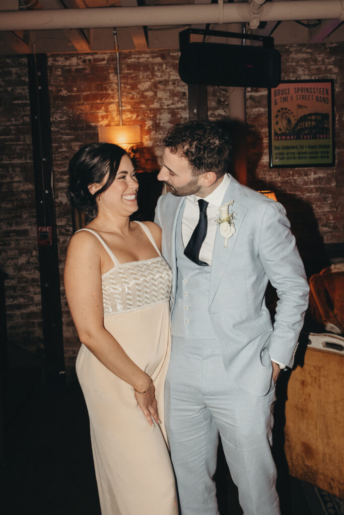 Sean and Giana smiling at each other during their Jersey City elopement reception portraits