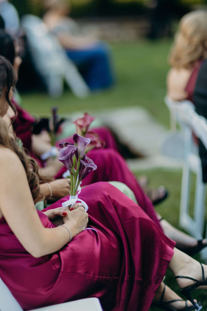 Bridesmaid holding purple calla lilies during Shay and Kevin's ceremony