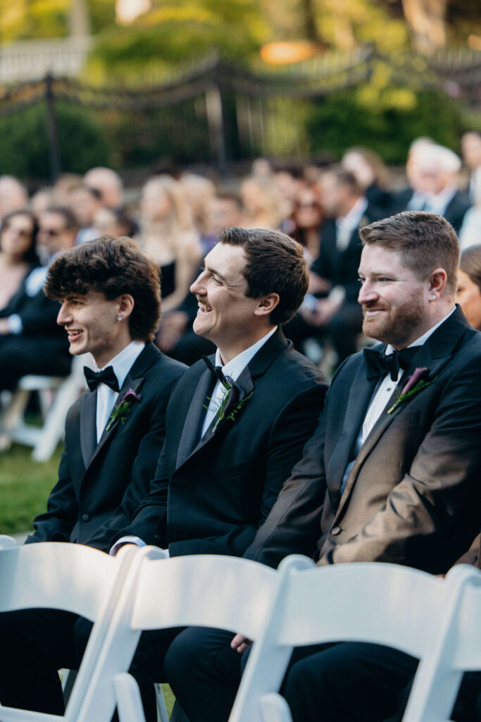Groomsmen smiling during Shay and Kevin's outdoor wedding ceremony