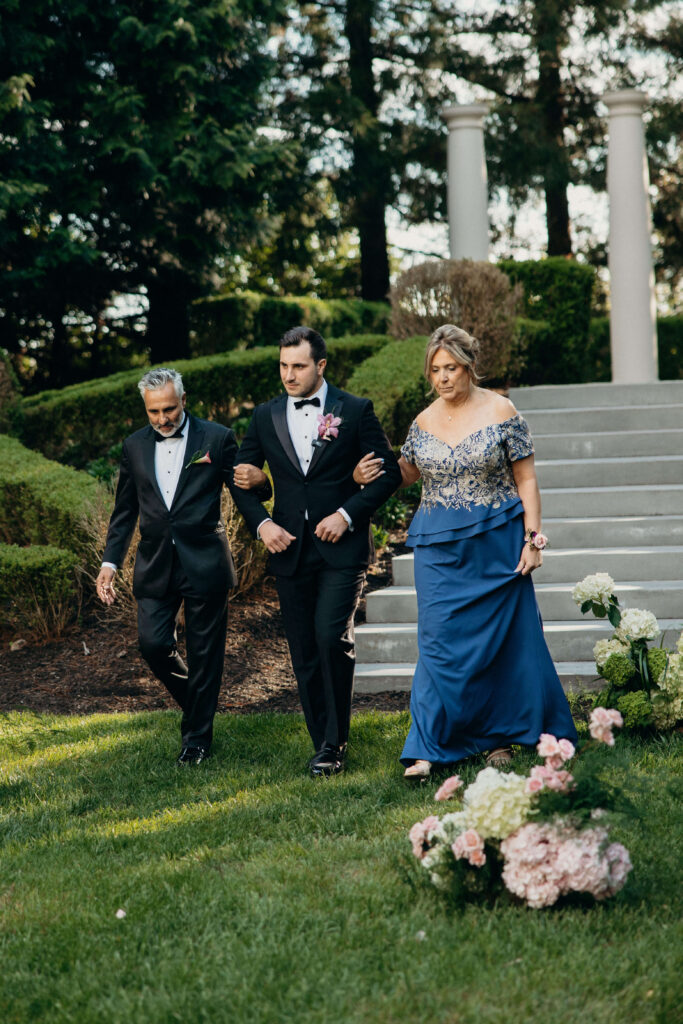 Groom walks down the aisle with his parents during The Ashford Estate wedding ceremony