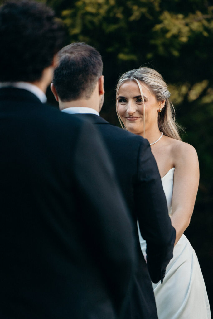 Bride smiles at the groom during their wedding vows at The Ashford Estate