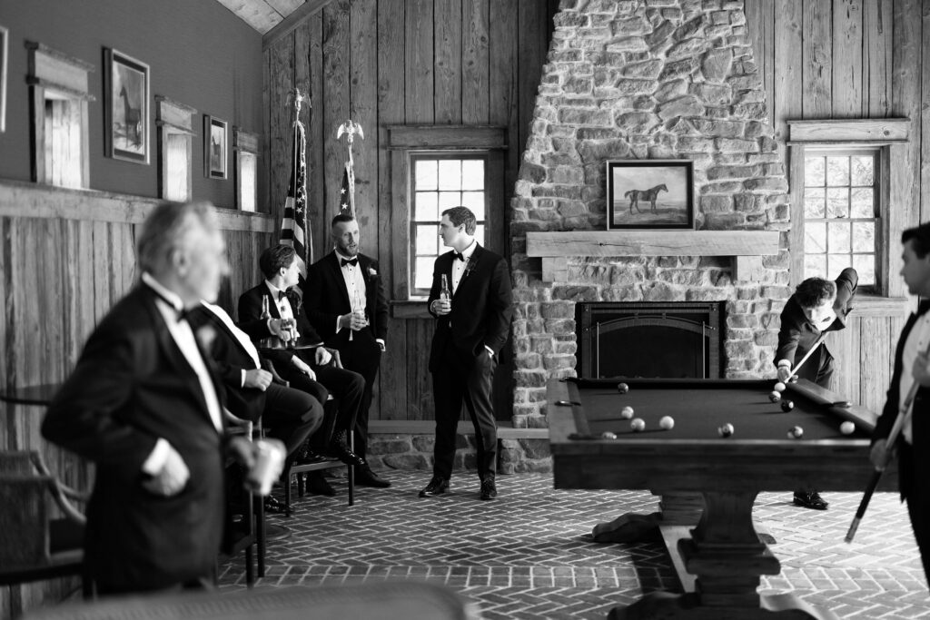 Groom lining up a shot during a game of pool with his groomsmen before the ceremony