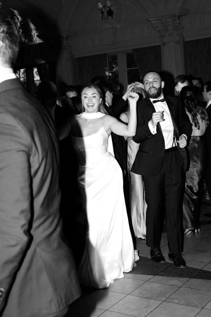 Black and white photo of guests and the bride dancing on the dance floor at The Ashford Estate