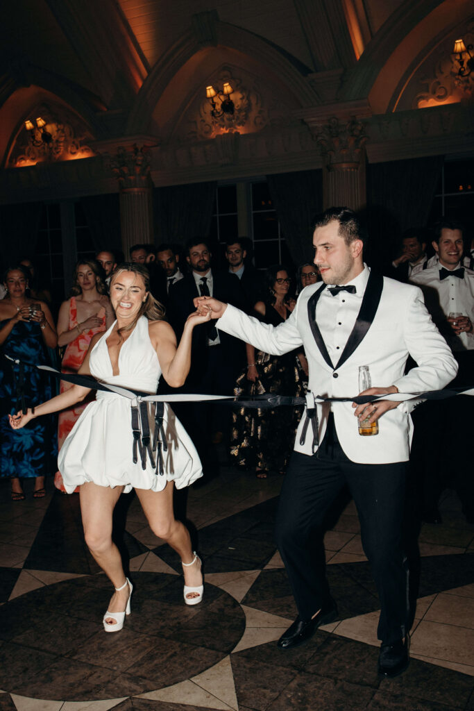 The bride and groom laughing and holding hands on the reception dance floor at The Ashford Estate