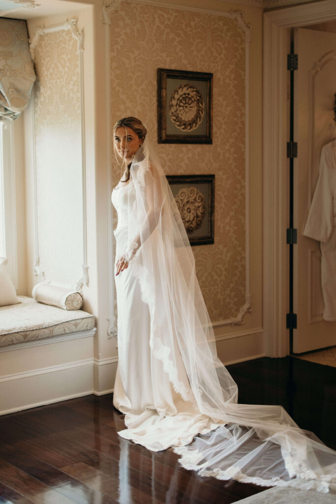 Bride Shay posing in her wedding dress and cathedral veil at The Ashford Estate