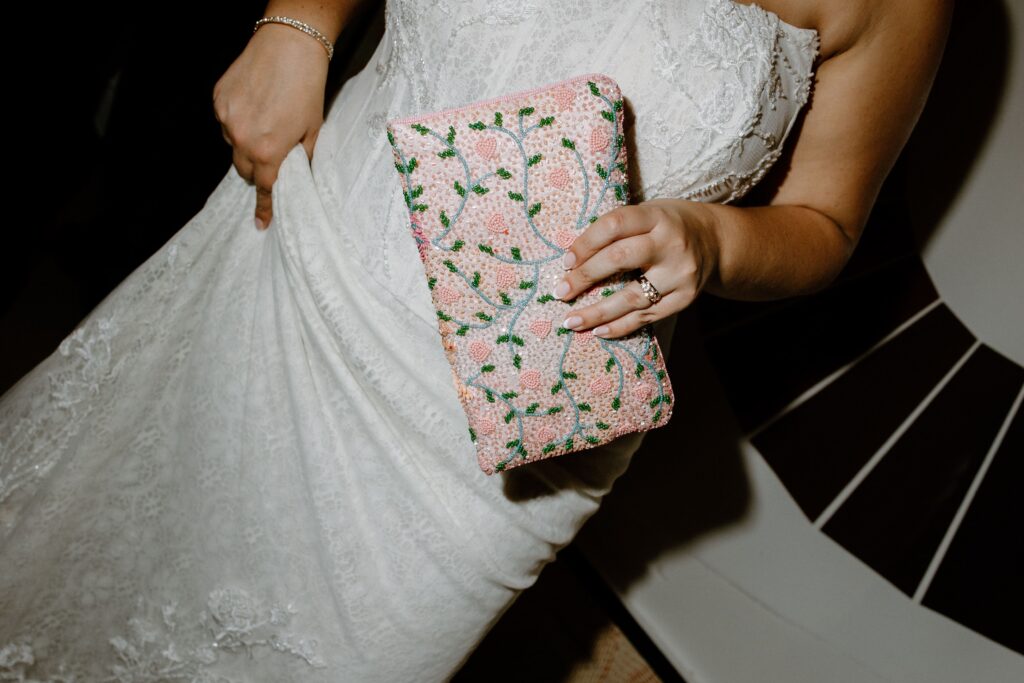 Bride holding a floral beaded clutch at Le Bilboquet, New York City | New Jersey wedding photographer