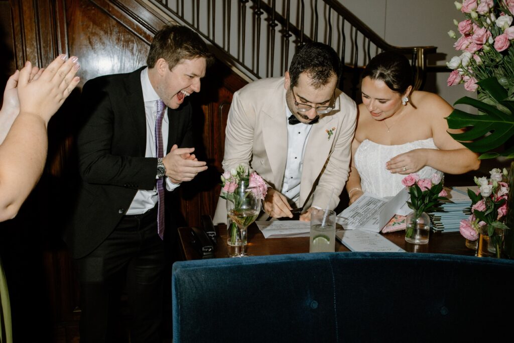 Newlyweds signing their wedding documents with guests at Le Bilboquet, New York City | New Jersey wedding photographer