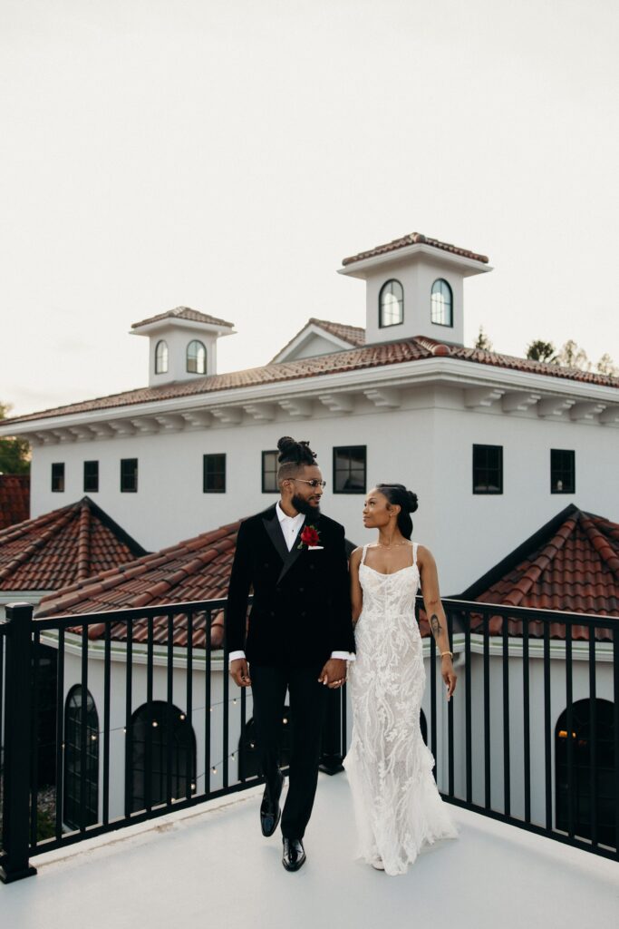 Bride and groom walking together on an outdoor terrace balcony at Perona Farms