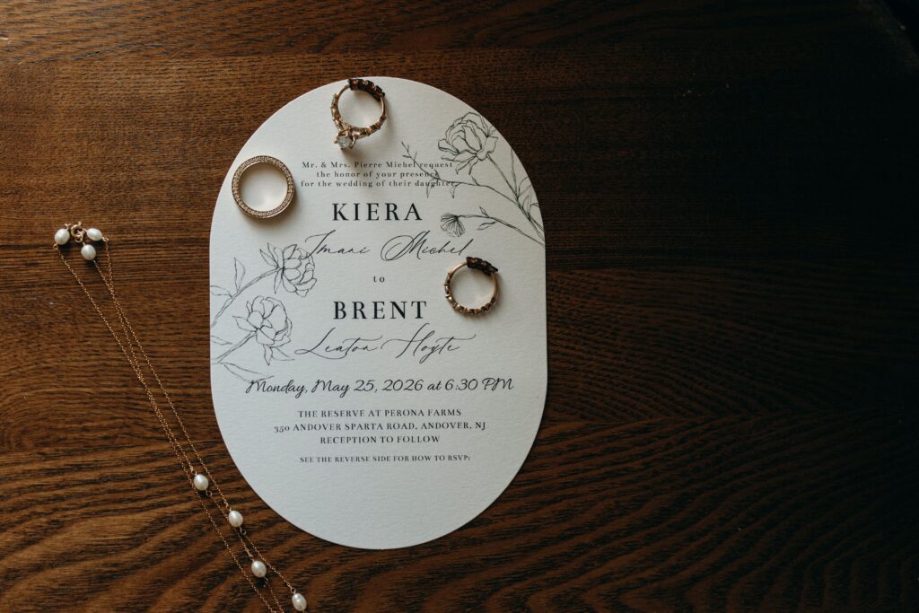 Elegant wedding invitation with rings resting on top at Perona Farms