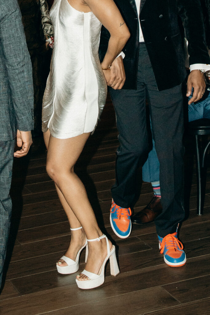 Close-up of a bride in platform heels and a groom in bright sneakers dancing at Perona Farms