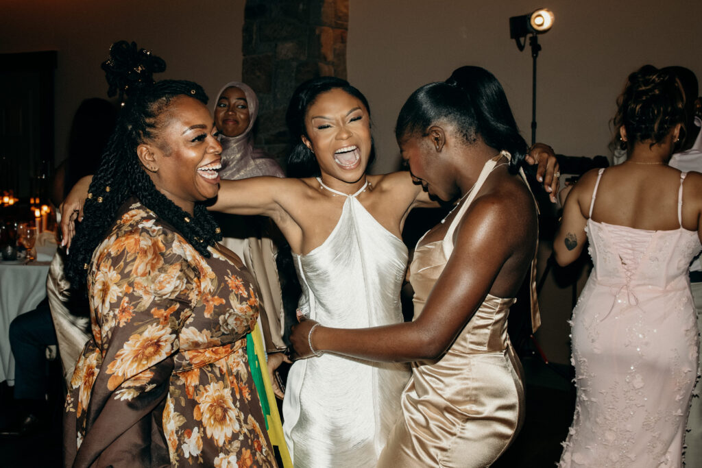 Bride dancing and laughing with guests on the dance floor at Perona Farms