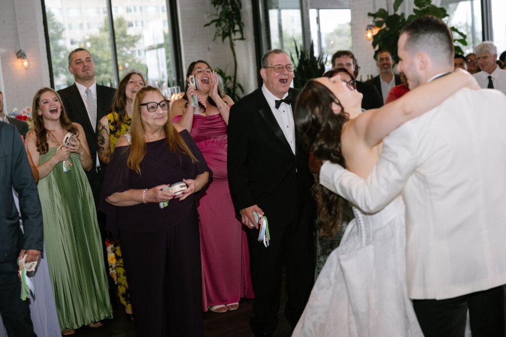 Guests cheering and celebrating while the couple dances at their wedding at Battello