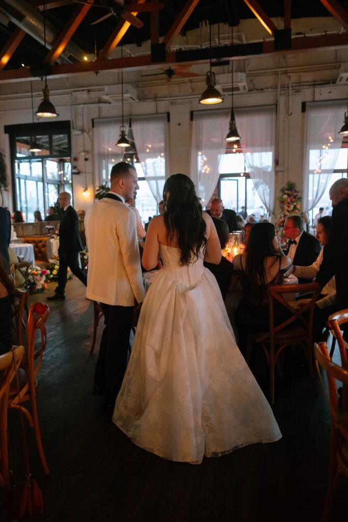 Back view of the newlywed couple looking over their wedding reception space at Battello