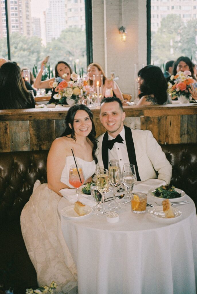 Bride and groom smiling at their sweetheart table during the wedding reception at Battello